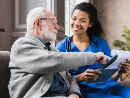 nurse and elderly man looking at the folder