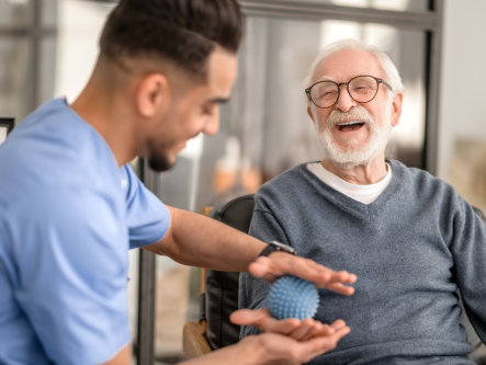 Patient having his hand massaged with a spiky massage ball