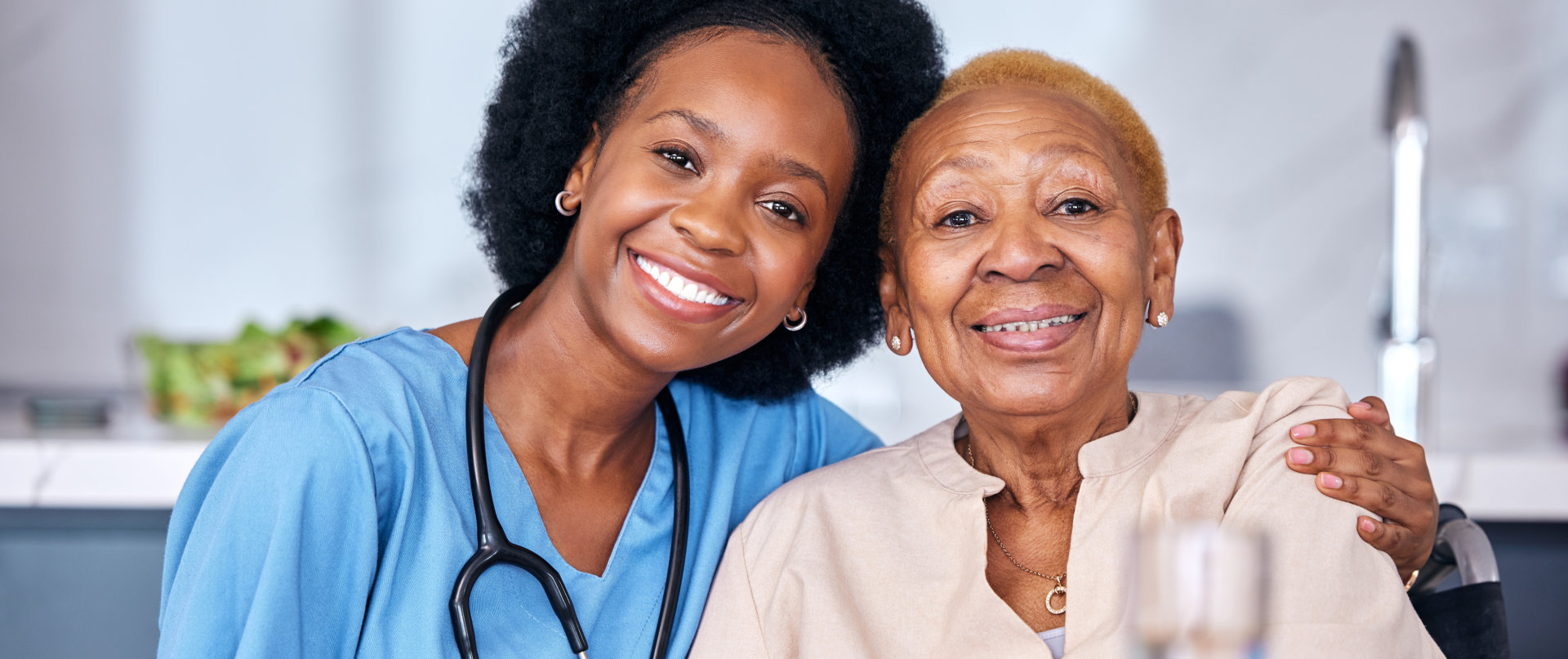 happy nurse and senior patient hugging