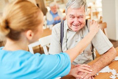 Nursing woman consoles a senior with dementia