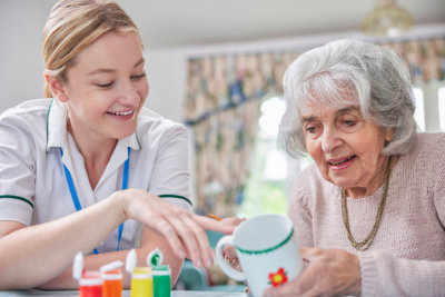 Woman Painting Cup With Art Therapist