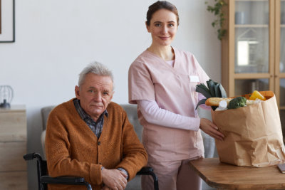 nurse and elderly man looking at the camera