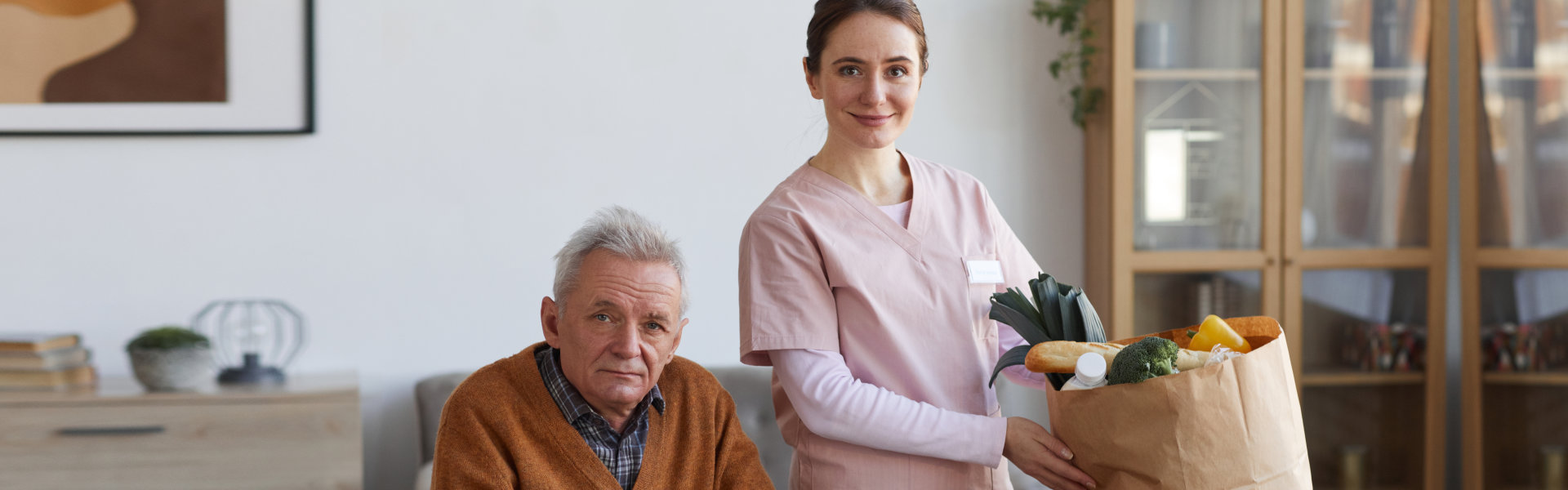 nurse and elderly man looking at the camera