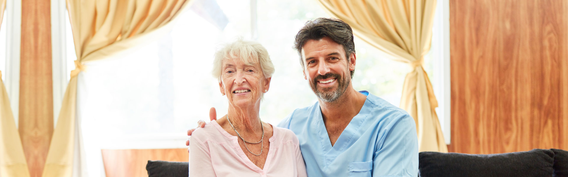 nurse and elderly woman smiling and looking at the camera