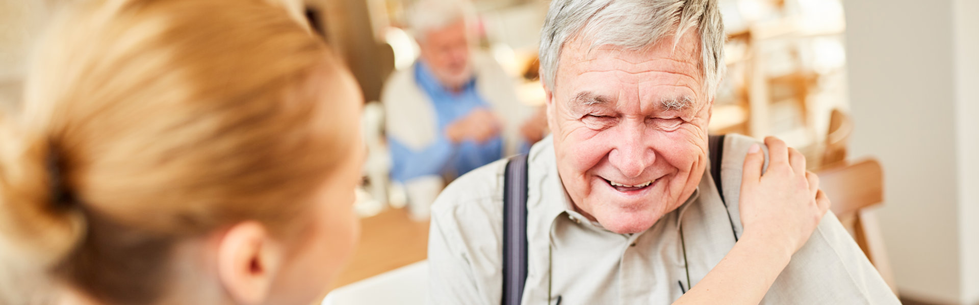 Nursing woman consoles a senior with dementia