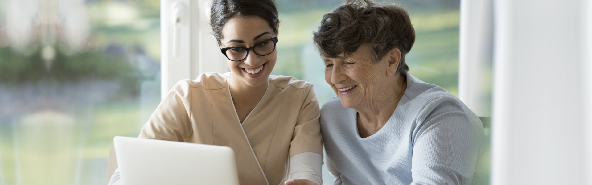 nurse and elderly woman looking at the camera